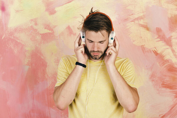 Musical lifestyle. American handsome bearded guy with headphones.