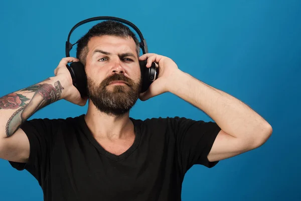 Dj con barba usa auriculares. Música, fiesta y concepto de ocio . — Foto de Stock