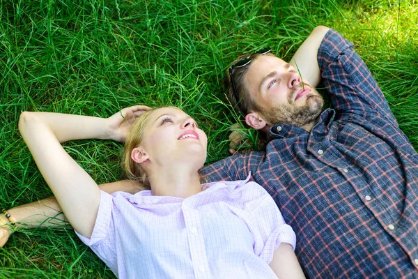 Nature fills them with freshness and peace. Man unshaven and girl lay on grass meadow. Closer to nature. Guy and girl happy carefree enjoy freshness of grass. Couple in love relaxing lay at meadow — Stock Photo, Image