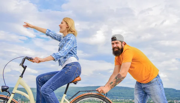 Feel impulse to start moving. Woman rides bicycle sky background. Push and promoting. Impulse to move. Man pushes girl ride bike. Support helps believe in yourself. Girl cycling while man support her — Stock Photo, Image