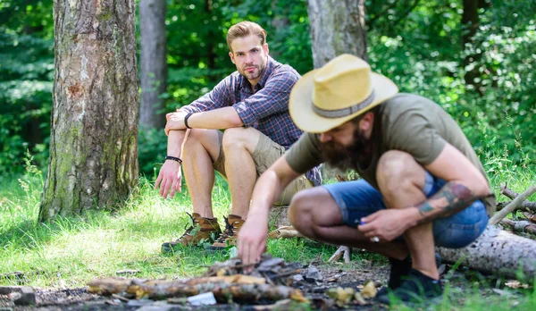 Manlighet koncept. Hur man bygger brasa utomhus. Män på semester. Man brutala skäggiga hipster förbereder brasa i skogen. Ordna woods kvistar eller trä pinnar. Ultimate guide till eldar — Stockfoto