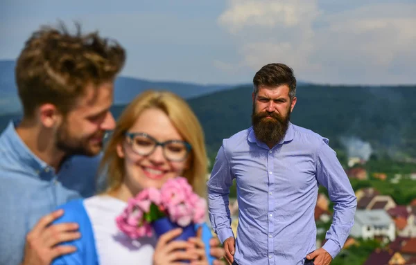 Casal apaixonado namoro enquanto homem barbudo ciumento assistindo esposa enganá-lo com amante. Casal romântico namorados flores bouquet. Os amantes abraços ao ar livre flertar relações românticas. Conceito de infidelidade — Fotografia de Stock