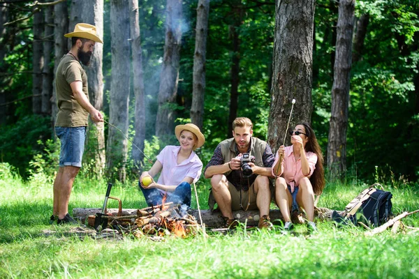 Spend great time on weekend. Halt for snack during hiking. Camping and hiking. Company friends relaxing and having snack picnic nature background. Company hikers relaxing at picnic forest background