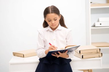 Yazmak için sıkıcı bir görev. Nasıl eğitim daha ilginç için ilk formers yapmak. Kız çocuk tutun kitap not edin. Çocuk okul üniforması sakin üzgün kayıtsız yüz yazma ders kitabı. Bilgi hakkında kayıtsız