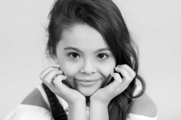 Маленька дівчинка з посмішкою на чарівному обличчі на синьому фоні — стокове фото