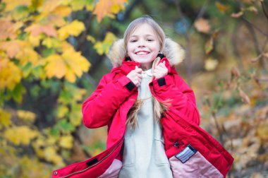Sıcak ceketle çok rahat hissediyorum. Sıcak ceket açık yürüyüş çocuk sarı uzun saçlı. Kız kat mutlu Sonbahar Doğa Parkı tadını çıkarın. Çocuk giyim moda ceket kukuleta ile. Sonbahar giyim ve moda kavramı