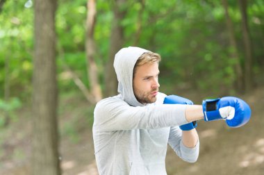 Sporcu eğitim boks eldivenleri yoğunlaşmıştır. Saldırı veya savunma her zaman hazır olun. Atlet yüz spor eldiven pratik becerileri doğa arka plan mücadele konsantre. Boksör boks üzerinde duruldu