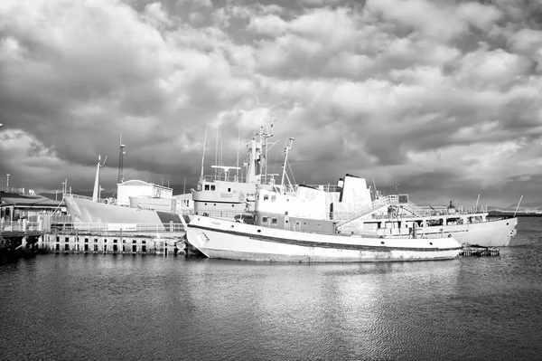 Рейкьявик, Исландия - 14 октября 2017 года: морские суда на побережье на облачном небе. Корабли на морском пирсе в маленькой деревне. Водный транспорт и морской транспорт. Отдых или странствия и путешествия — стоковое фото