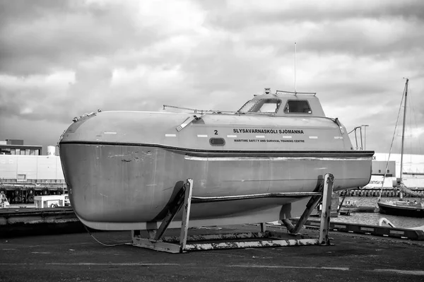 Reykjavik, Islandia - 14 de octubre de 2017: barco del centro de entrenamiento de seguridad marítima y supervivencia en la orilla del mar. Barco naranja o bote salvavidas en el cielo nublado. Seguridad o búsqueda y rescate. Transporte y transporte — Foto de Stock