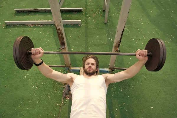 Homem musculoso treino no ginásio fazendo exercícios com barbell — Fotografia de Stock