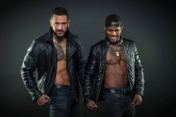 Maskulinitet och brutalitet koncept. Män på leende ansikten med borst. Män med sexig muskulös torsos ser brutalt. Machos med muskulös torsos ser attraktiva i skinnjackor, mörk bakgrund — Stockfoto