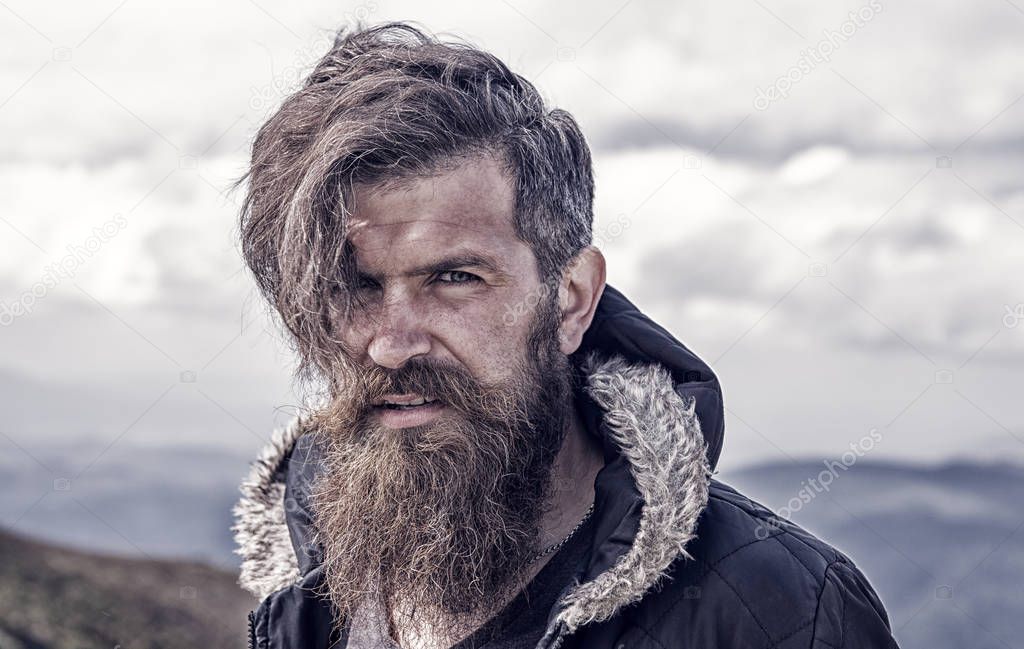 man hipster traveler with beard and moustache portrait on mountain