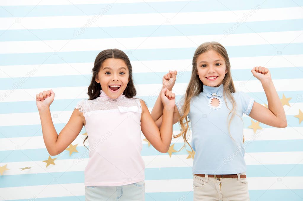 Thrilled moments together. Kids schoolgirls preteens happy together. Girls smiling happy faces excited expression stand striped background. Girls children best friends thrilled about surprising news