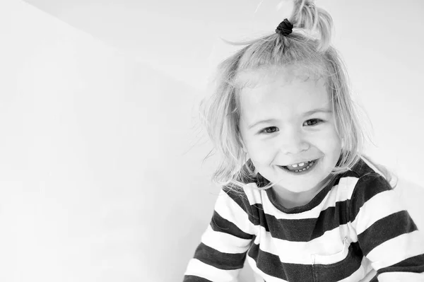 Un niño sonríe vestido de azul marino. Feliz niño disfruta de un día soleado. Niño sonriendo con cola de caballo de pelo rubio. Moda y estilo para niños. Vacaciones de verano, ocio y diversión concepto, espacio de copia — Foto de Stock