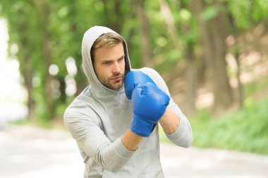 Yeteneklerini keskinleştirmek. Sporcu eğitim boks eldivenleri yoğunlaşmıştır. Atlet yüz spor eldiven pratik becerileri doğa arka plan mücadele konsantre. Boksör yakışıklı sıkı boks. Spor kampı kavramı