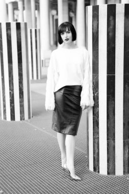 Paris, Fransa 'da kırmızı dudaklı bir kadın. Esmer saçlı, şehvetli bir kadın. Çekici görünüşlü güzel kız. Beyaz bluz ve deri etek giyen manken. Moda ve bak. İş başarısı.