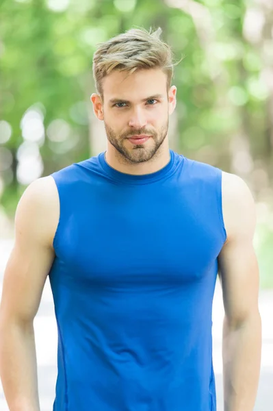 Proud to be strong. Man sporty outfit looks confident outdoors nature background. Guy bearded muscular body proud of his shape. Sportsman enjoy his muscular body proud of himself