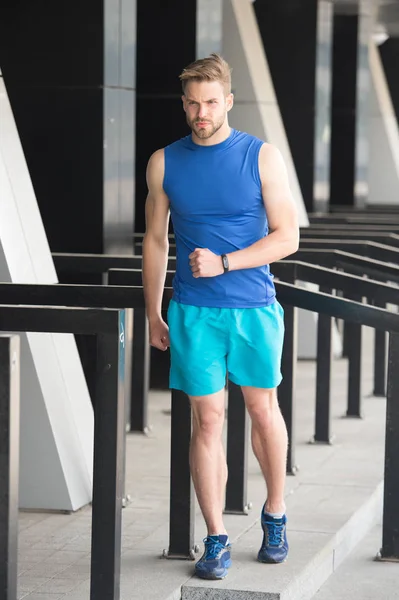 En camino al éxito. Entrenamiento de deportista con gadget podómetro en el estadio. Concepto de gadget deportivo. Hombre atleta cara estricta con equipo deportivo de fondo urbano. Rastreador de fitness atleta o podómetro — Foto de Stock