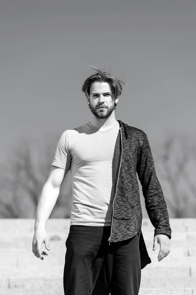 Homem com barba usar tshirt ao ar livre ensolarado, moda. Macho fica no céu azul, perspectiva. Moda e estilo dos homens. Perspectiva, futuro, liberdade . — Fotografia de Stock