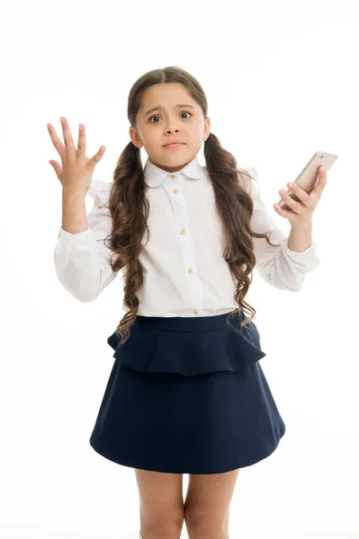 Meisje schattig lang krullend haar houdt smartphone witte achtergrond. Kind wanhopige hulpeloze gezichtsuitdrukking houdt smartphone. Praten met vrienden online communicatie. Slechte verbinding. Probleem met de celverbinding — Stockfoto