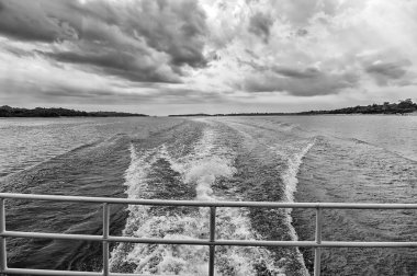 Hız ve enerji kavramı. Manaus, Brezilya mavi denizde su üzerinde iz. Bulutlu gökyüzü ufukta deniz kıyısında. Yolculuk tutkusu keşif ve macera. Su ile seyahat