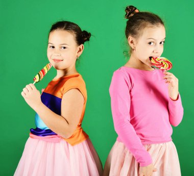 Yeşil zemin üzerine şeker ile çocuk mutlu yüzler ile poz.