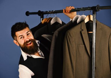 Giysi raf tarafından sakallı adam. İşadamı heyecanlı yüz