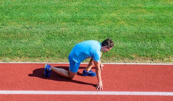 Joint mobility exercises to improve flexibility and function. Athlete runner prepare to race. Running tips for beginners. Man athlete stand low start position stadium path. Runner ready to go