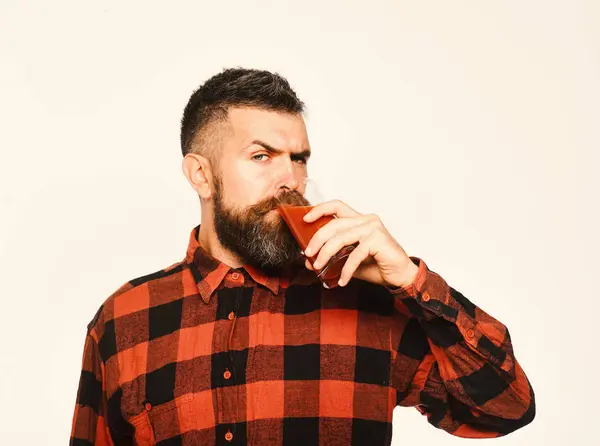 Rolnik z surową twarzą pije szklankę świeżego czerwonego soku — Zdjęcie stockowe