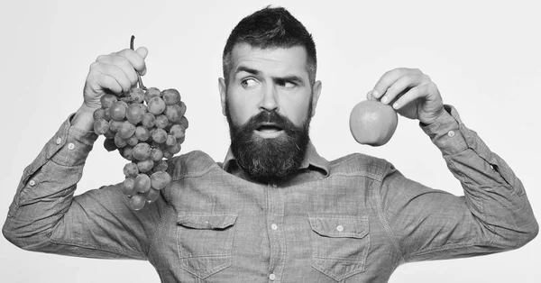 Mann mit Bart hält Trauben und Apfel in der Hand — Stockfoto