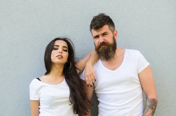 Romantic couple. Couple white shirts cuddle each other. Hipster bearded and stylish girl hang out urban romantic date. Couple in love hang out together grey wall background. Couple stylish youth