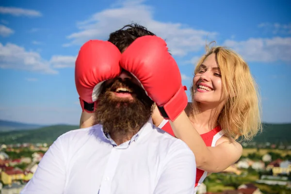Cunning tricks to win. Guess who game. Relations game or struggle. Break rules to success. Play and have fun. Tricks every woman needs to know. Girl smiling face covers male face with boxing gloves
