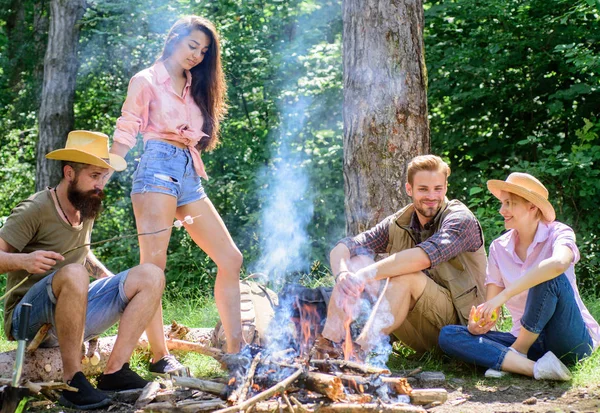 Trevlig helg nära lägerelden. Vänner njuta av sommaren semester eller weekend skog. Företaget vänner avkopplande nära lägerelden. Sommarsemester. Bästa vänner tillbringa fritid helgen skog natur bakgrund — Stockfoto