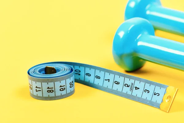 Ginásio e equipamentos de estilo de vida saudável. Dumbbells e fita métrica — Fotografia de Stock