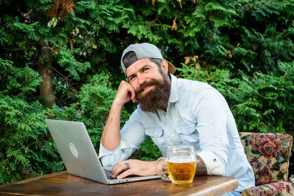 Brutalny człowiek wypoczynek z piwem i gry sportowe. Fan piłki nożnej Brodaty hipster zrobić zakład sport gry laptop. Facet siedzieć taras na świeżym powietrzu z piwem. Typuj i stawiaj na Mistrzostwa świata. Zakładów i gier na prawdziwe pieniądze — Zdjęcie stockowe