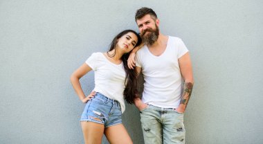 Genç ve şık. Gençlik şık kıyafet basit ama modern. Kaç arkadaş birlikte takılmak. Çift beyaz gömlek gri duvara yakın kucaklamak. Acımasız ve şık moda kız takılmak hipster sakallı