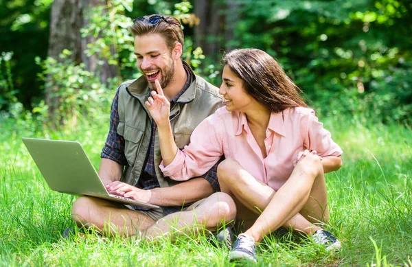 Couple youth spend leisure outdoors with laptop. Modern technologies give opportunity to be online and work in any environment conditions. Freelance opportunity. Man and girl looking at laptop screen