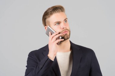 Bağlantı bekleyin. İyi bakımlı adam cep telefonu gri arka plan konuş. İşadamı ciddi çağrı cep telefonu. Mobil telefon bağlantısı. Adam yakışıklı çekici ofis çalışanı biliyor cep telefonu