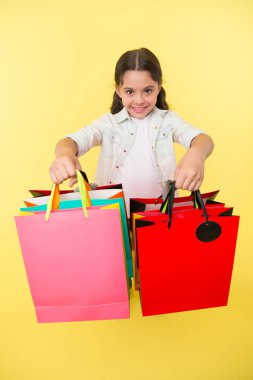 Onun alışveriş paketleri kontrol edin. Kız alışveriş torbaları sarı arka plan taşır. Kız alışveriş düşkün. Çocuk şirin Alışverişkoliğin grup alışveriş torbaları ile siyah Cuma toplam satış. Alışveriş paketleri al