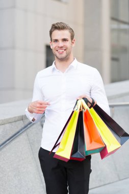 Adam resmi kıyafet alışveriş torbaları taşımak. Adam mutlu taşımak grup alışveriş torbaları. Karlı fırsatlar siyah Cuma. Bir dakika dostum çok kağıt çanta paketleri alışveriş merkezinde alışveriş sonra. Siyah Cuma satış konsepti