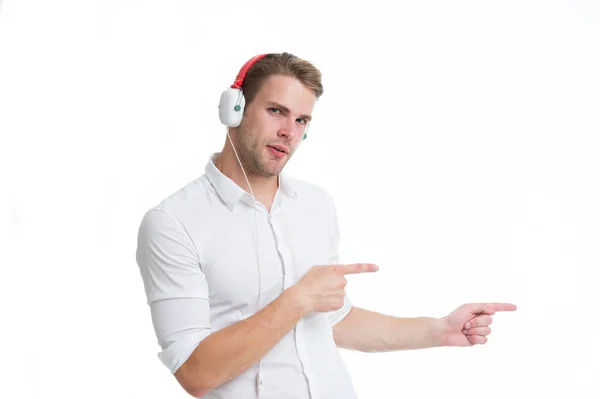 Man in headphones pointing index finger isolated on white. Assistant call center help find direction. Guy call service worker shows direction. Look at this guide. Man listen music headphones — Stock Photo, Image