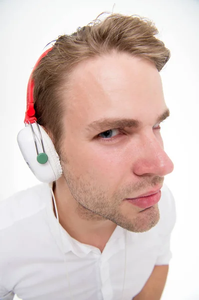 Шпигунська концепція. Чоловік підозріло слухає навушники як шпигун. Хлопець з навушниками слухає звук. Чоловік підозріло слухає навушники білий фон крупним планом. Таємні шпигунські прослушки. Технологія використання шпигуна — стокове фото