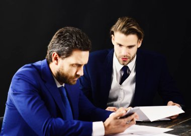 Kağıt iş ve ekonomi kavramı. Meşgul insanlar belgeleri okumak ve smartphone vasıl bak. Erkekler sakalları ve ciddi yüzler ofisinde çalışıyorum. Başarı, ortaklık, para. İş ortakları kadar başlangıç oluşturma