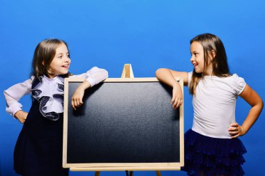 Çocuklar okul kıyafetleri giyen parlak yazı tahtası üzerinde yalın