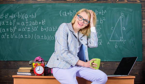 Working conditions for teachers. Working conditions which prospective teachers must consider. Woman smiling teacher holds mug drink sit table classroom chalkboard background. Take a break to relax — Stock Photo, Image