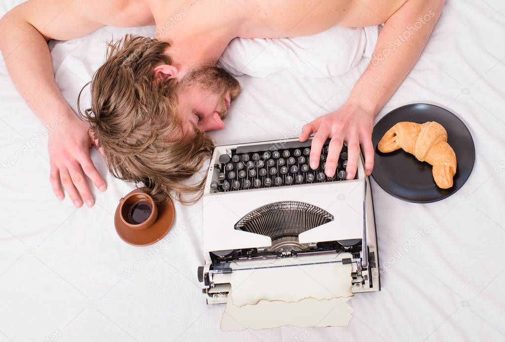 Writer used old fashioned typewriter. Man sleepy lay bedclothes while work. Workaholic fall asleep. Author tousled hair fall asleep while write chapter top view. Man with typewriter coffee lay bed