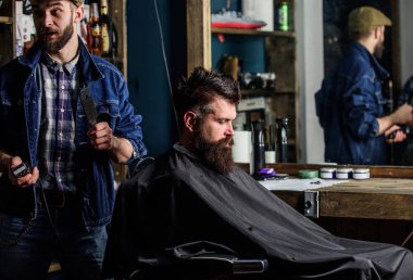 Kuaför saç kesme makinesi ile saç modeli sakallı adam berber arka plan için çalışır. Kesme makinesi ve acımasız sakallı istemci ile berber. Hipster istemci Başlarken saç kesimi. Hipster yaşam tarzı kavramı