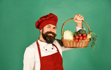 Yeşil zemin üzerine sakallı adam. Şef sebze tutar