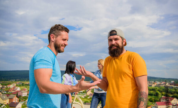 У них есть тема для обсуждения. Связь по интересам. Друзья группы тусуются с велосипедом. Компания стильные молодые люди проводят досуг на открытом воздухе небо фоне. Встречайте веселых друзей во время прогулки
