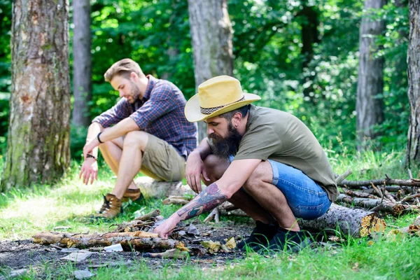 Conceito de masculinidade. Guia final para fogueiras. Como fazer fogueira ao ar livre. Homens de férias. Homem brutal hipster barbudo prepara fogueira na floresta. Organizar os galhos de madeira ou varas de madeira — Fotografia de Stock